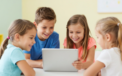 Četri bērni smaidot skatās uz planšetdatoru, kas redzams no aizmugures — attēls ALPA Kids emuāra rakstam par piecām lietām, kas jāzina pirms bērna pirmā ekrāna laika